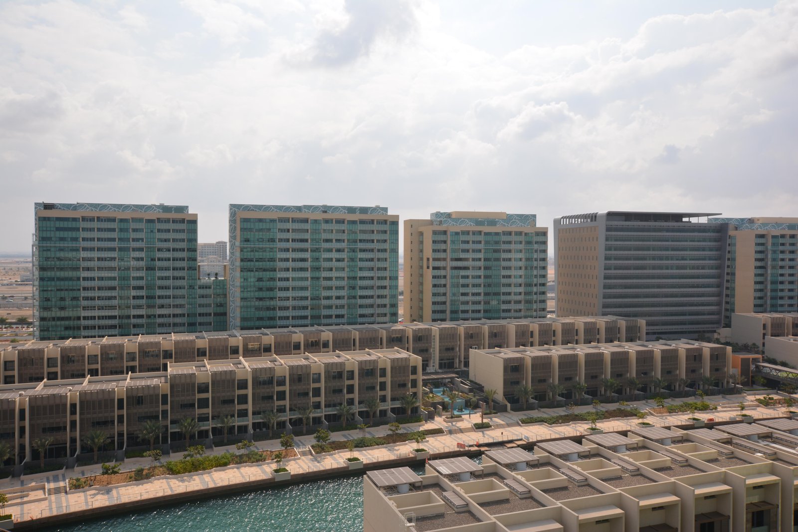 Modern coastal architecture of Al Zeina residential buildings in Al Raha Beach Abu Dhabi featuring beachfront apartments.
